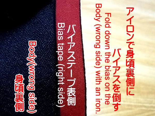 Folding bias tape to the wrong side of the bodice with an iron