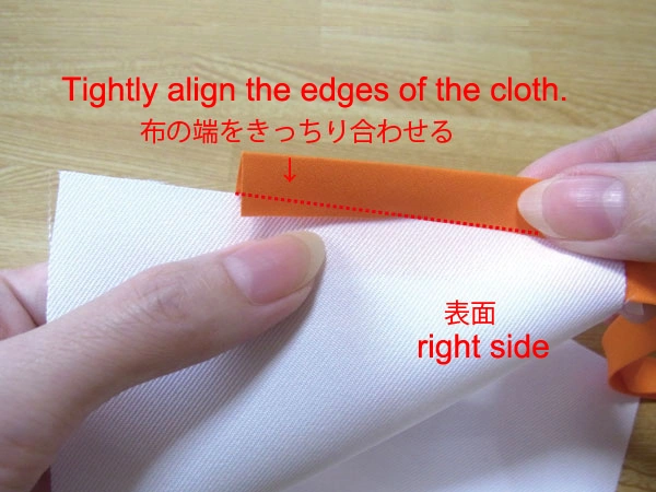Aligning the edges of the fabric and bias tape tightly