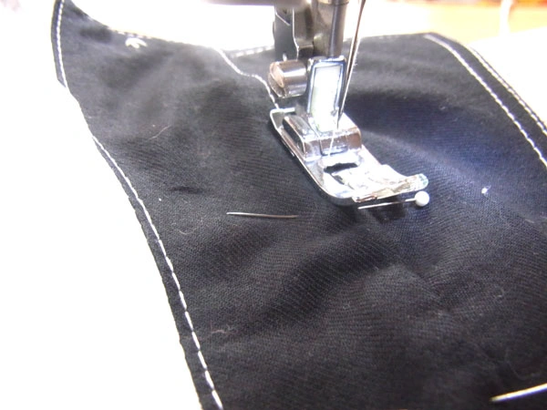 Carefully sewing collar stand with pins in place