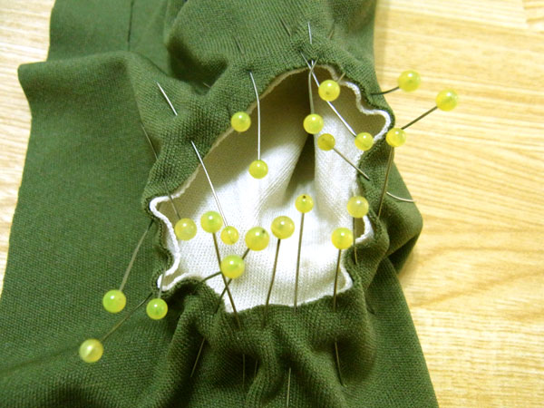 Pinning curved edges of the thumb piece to glove base