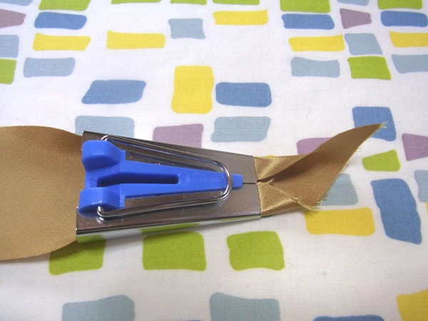 Golden satin being inserted into tape maker