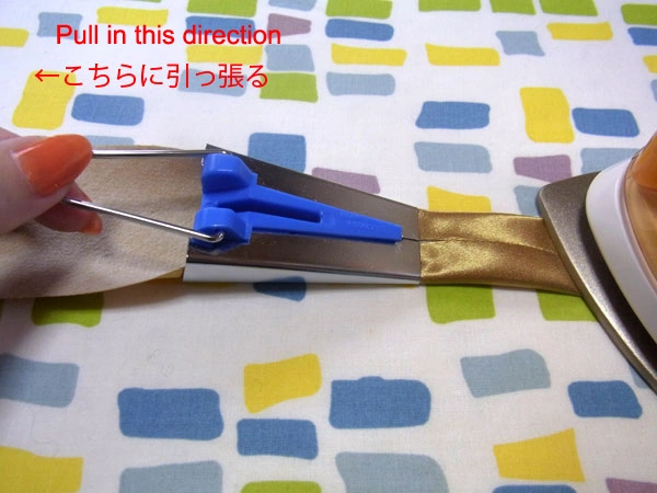 Golden satin with fusible interlining pulled through tape maker