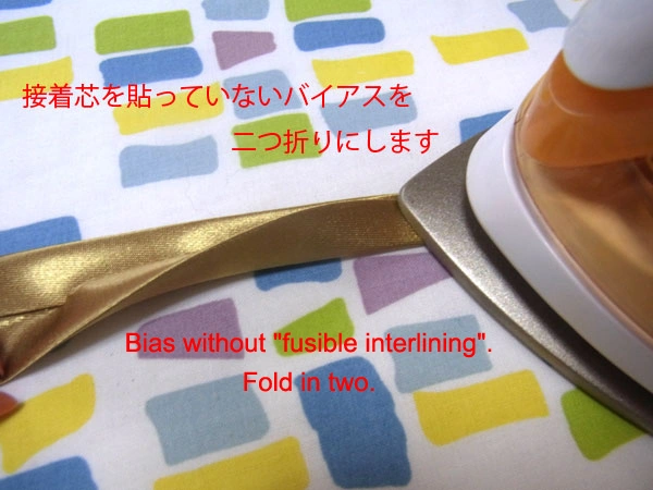 Ironing satin bias tape with fusible interlining folded in two